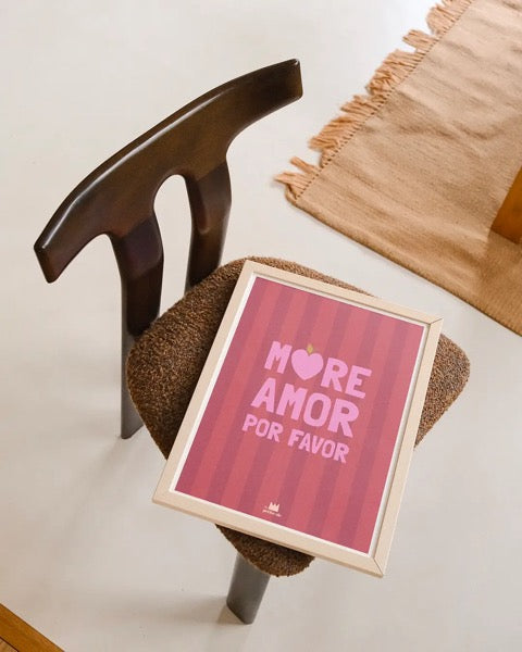 Affiche More Amor por favor encadrée posée sur une chaise